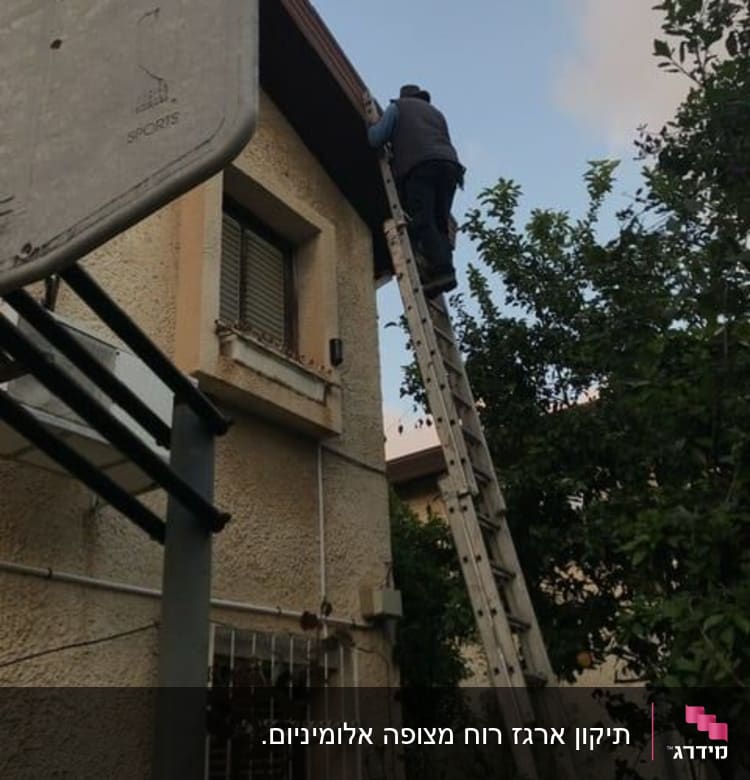 אדם על סולם מתקן גג של בית